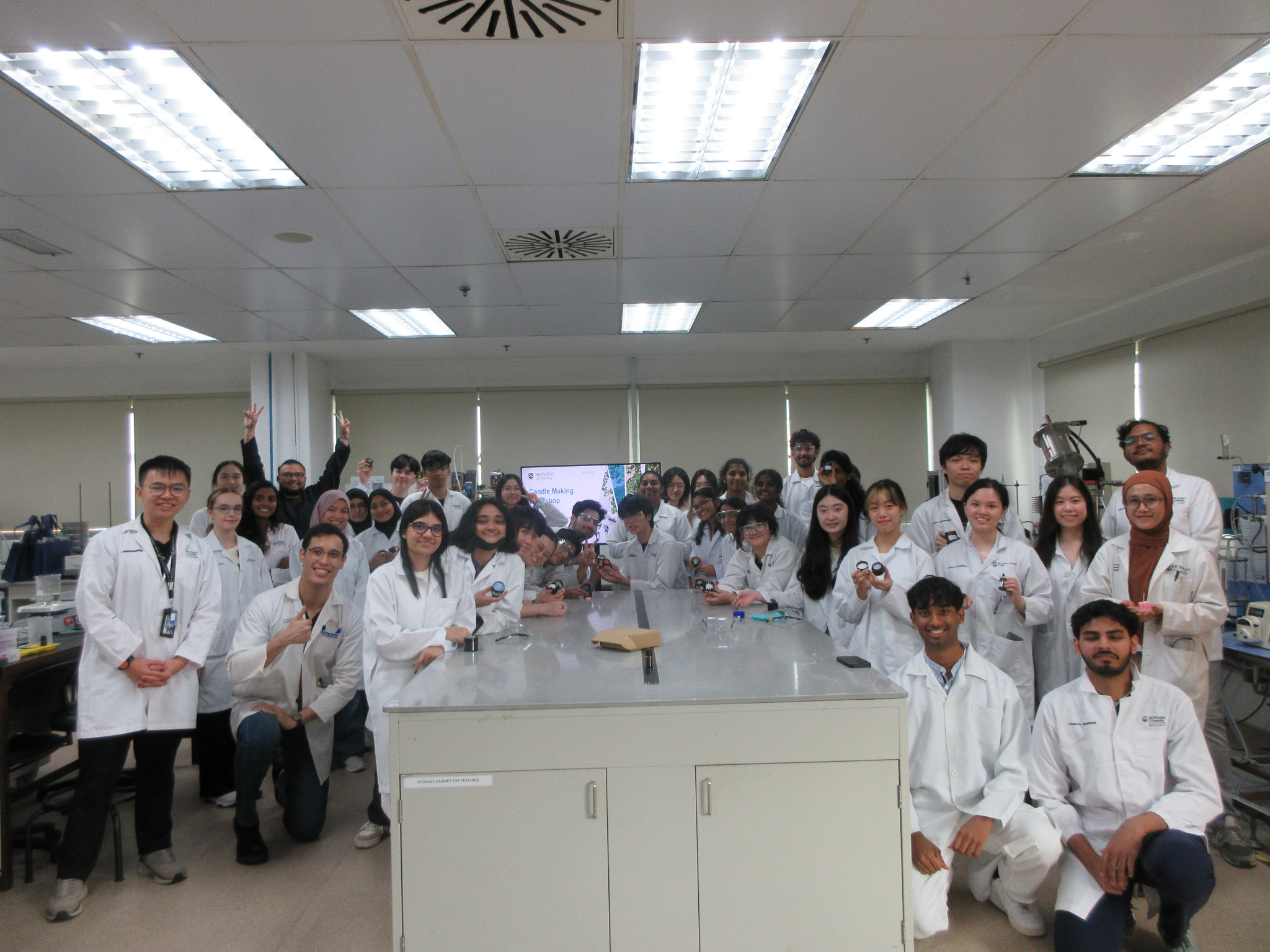 Participants in laboratory coats at a candle-making workshop at Monash University Malaysia