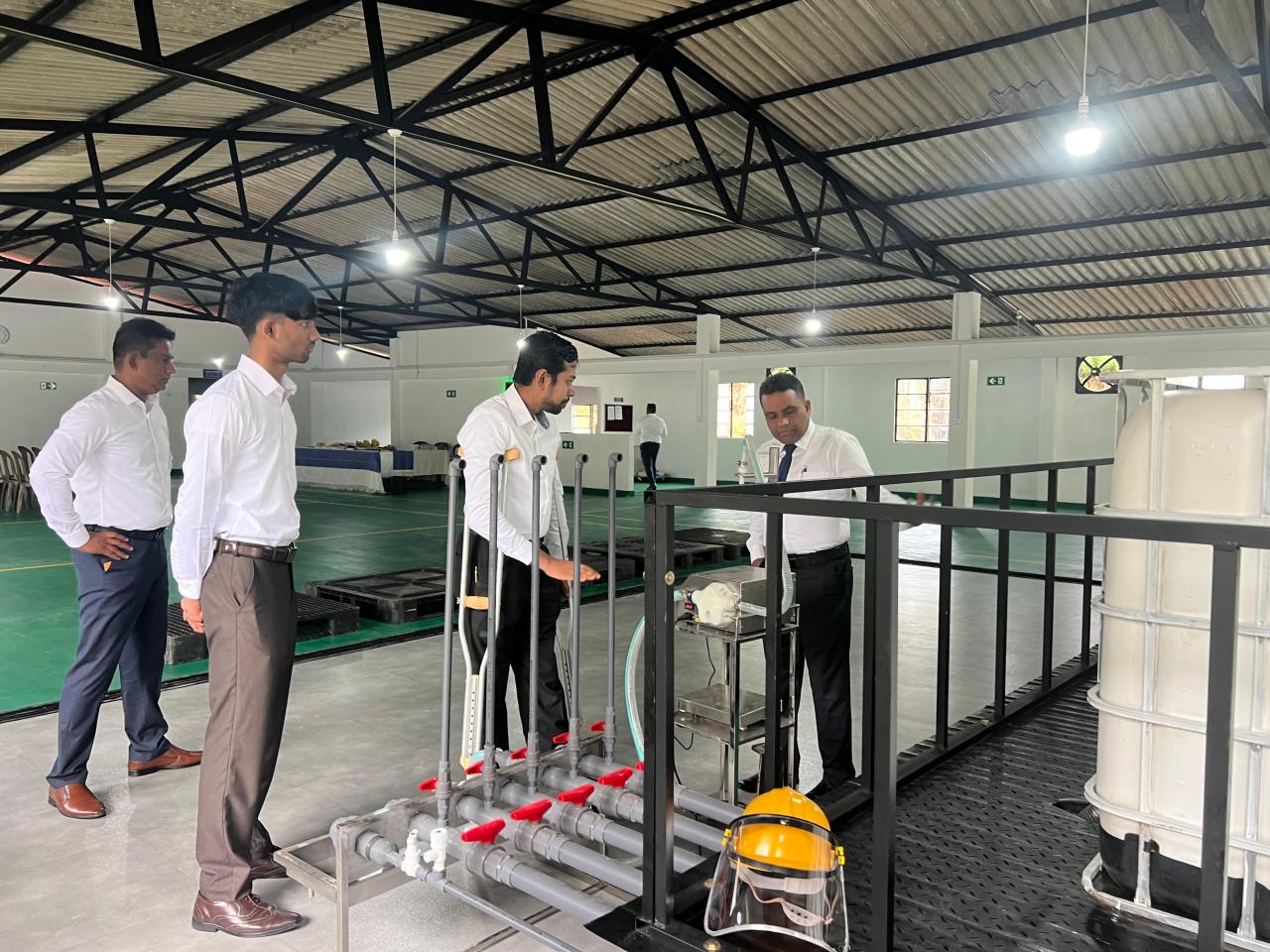 Aloka with colleagues inspecting equipment at the internship facility