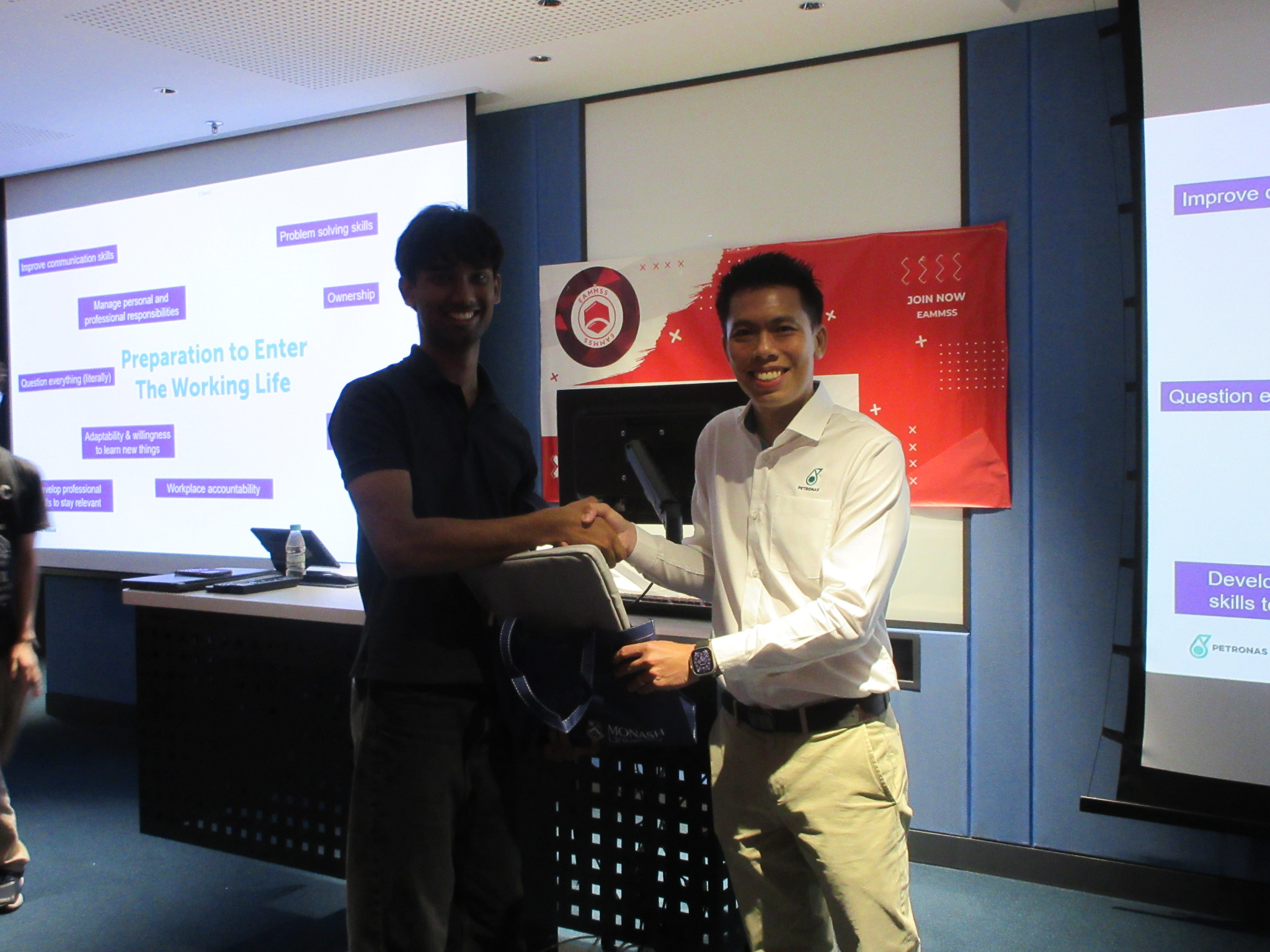 Aloka greeting a PETRONAS representative after an engineering workshop